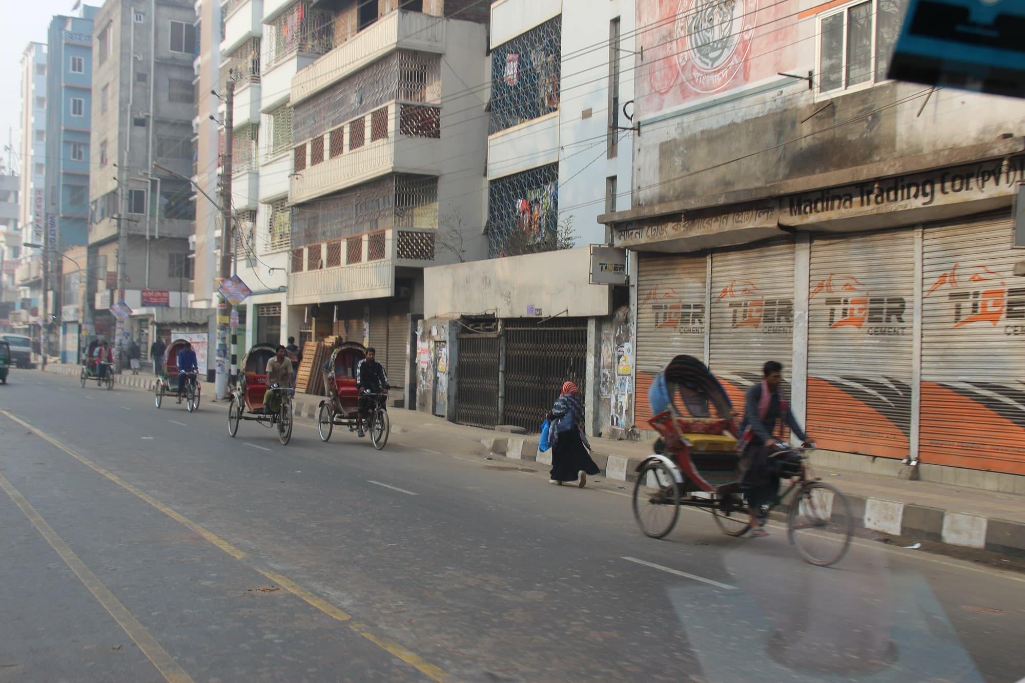 Cycle rickshaws on a wide street in Dhaka