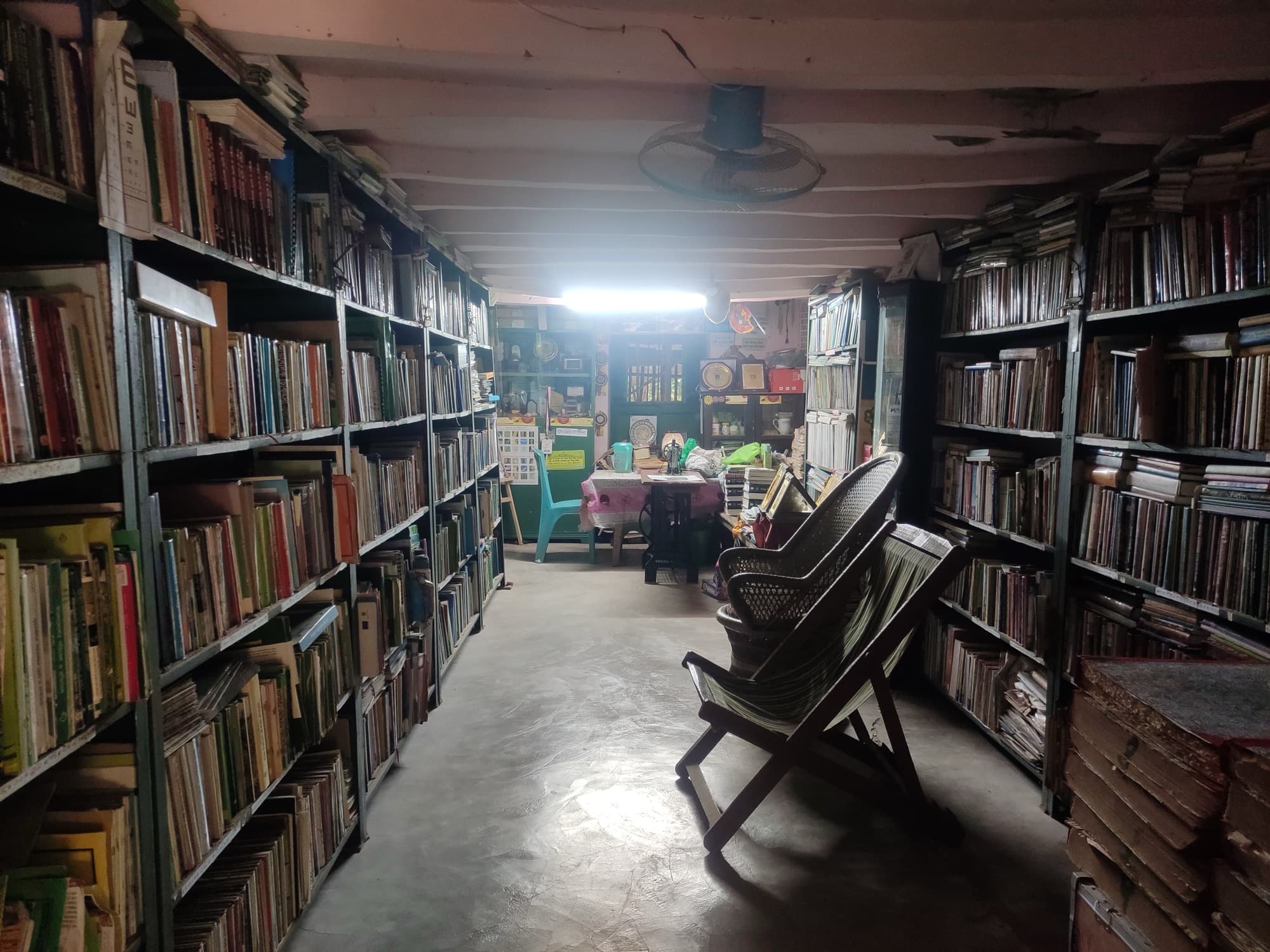 A narrow aisle between tall bookshelves in a reading room